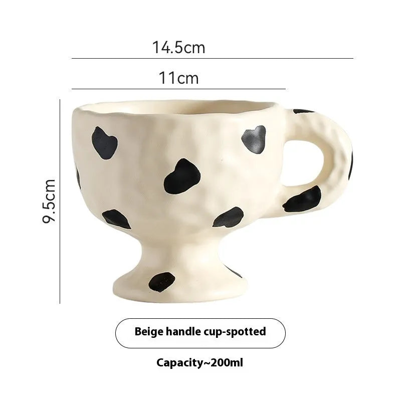 Hand-pinched irregular shaped ceramic mug in a solid colour on a table.