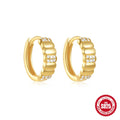 A pair of small, round, geometric stud earrings made of sterling silver with an electroplated finish.