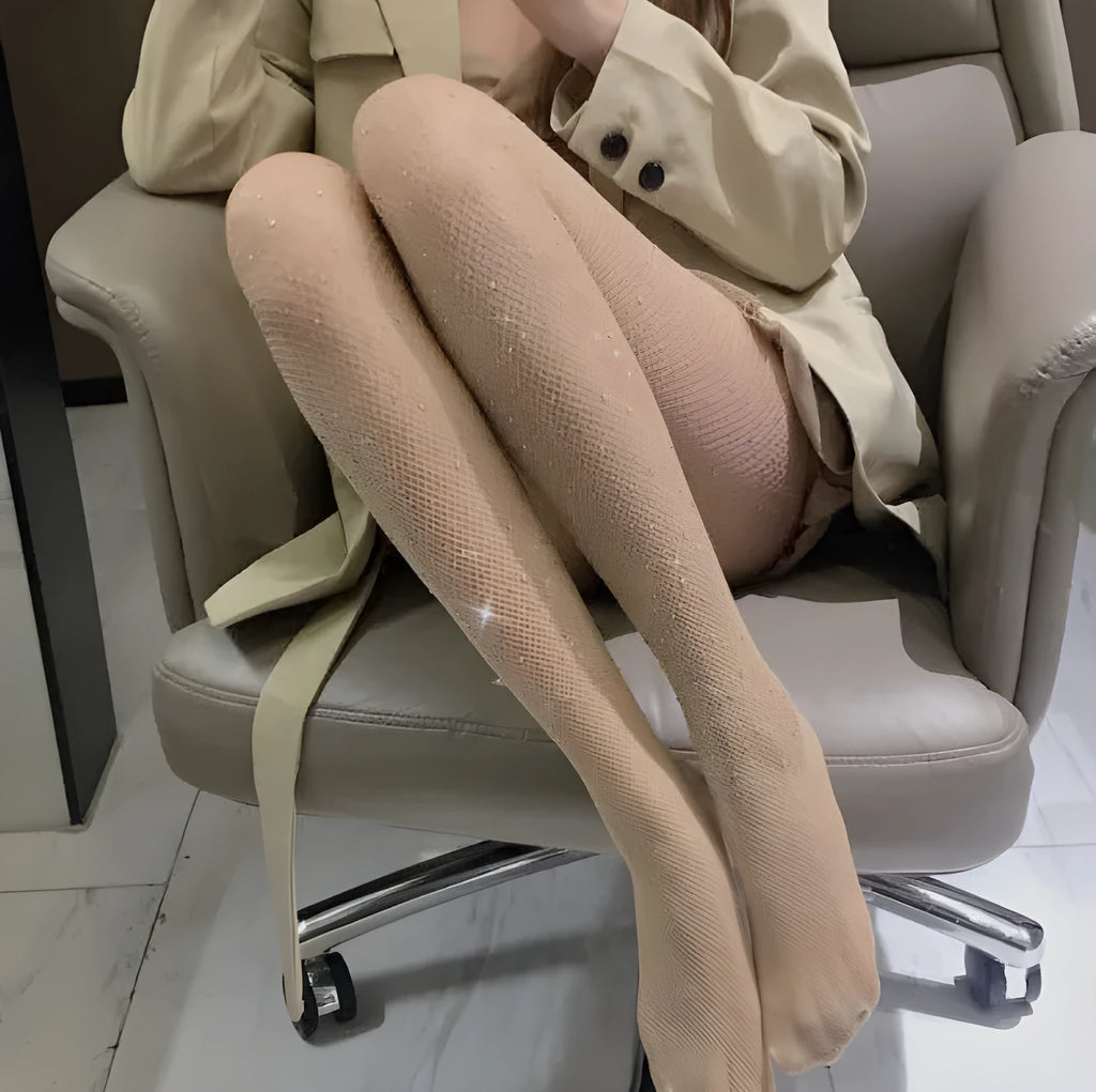 A pair of thin mesh fishnet stockings for women in solid skin colour, laid flat.
