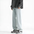 Men's light blue washed straight leg jeans with a button waist on a plain background.