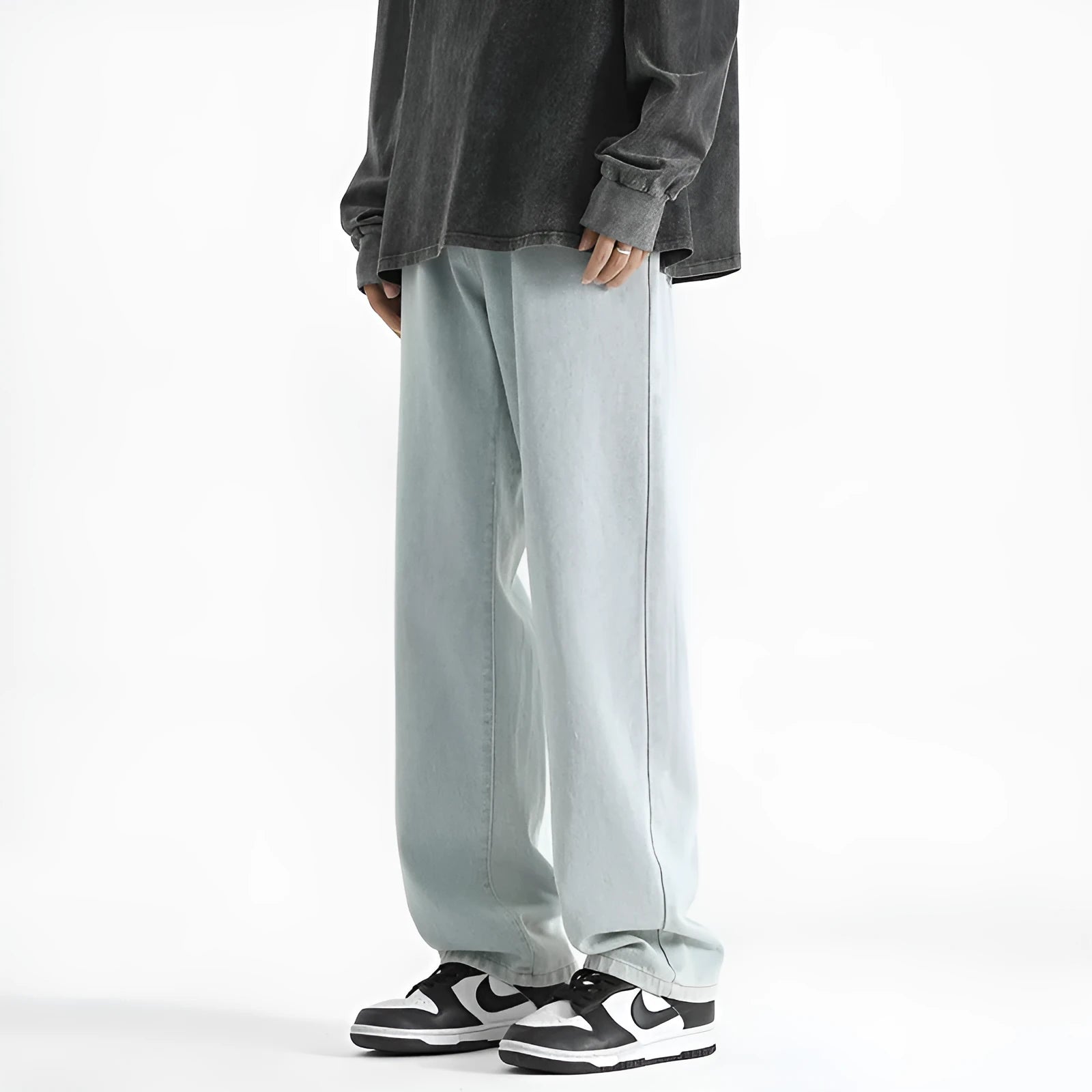 Men's light blue washed straight leg jeans with a button waist on a plain background.