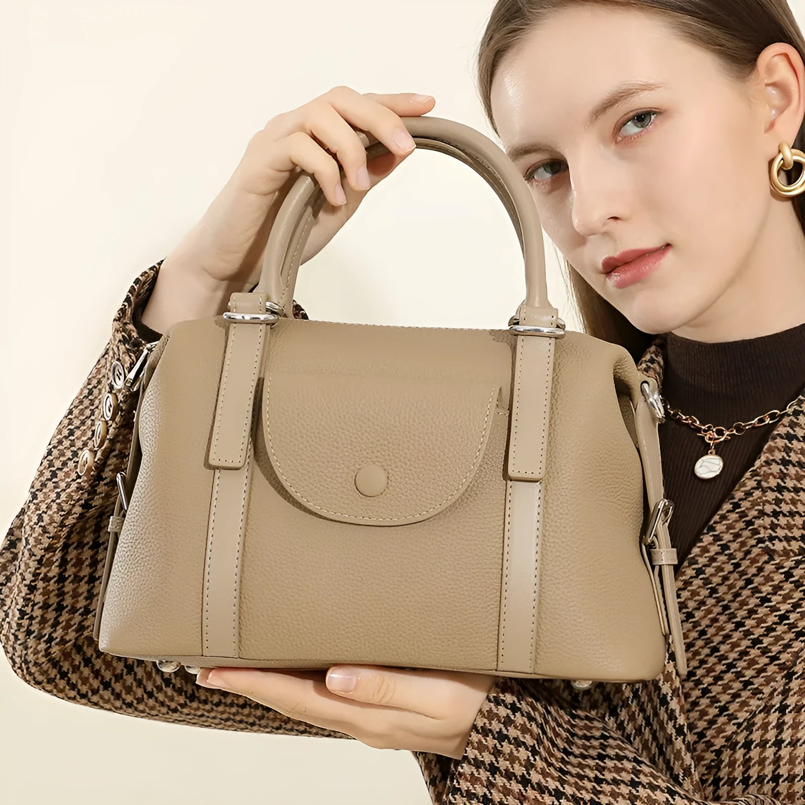 Black genuine leather ladies handbag with single shoulder strap, showing contrast lock and stitching.