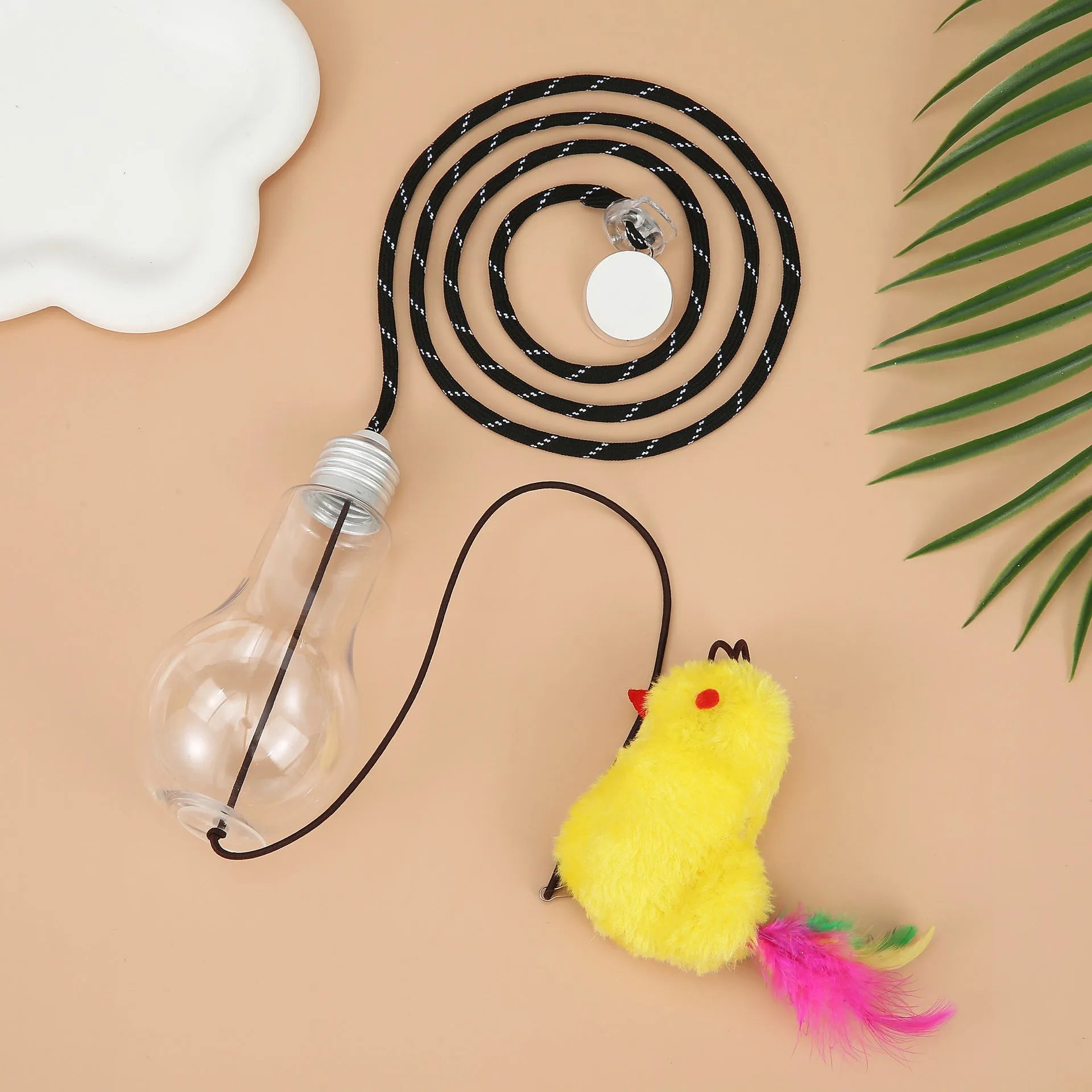 Grey and yellow retractable cat teaser toy hanging on door frame with treat bulb and dangling mouse.
