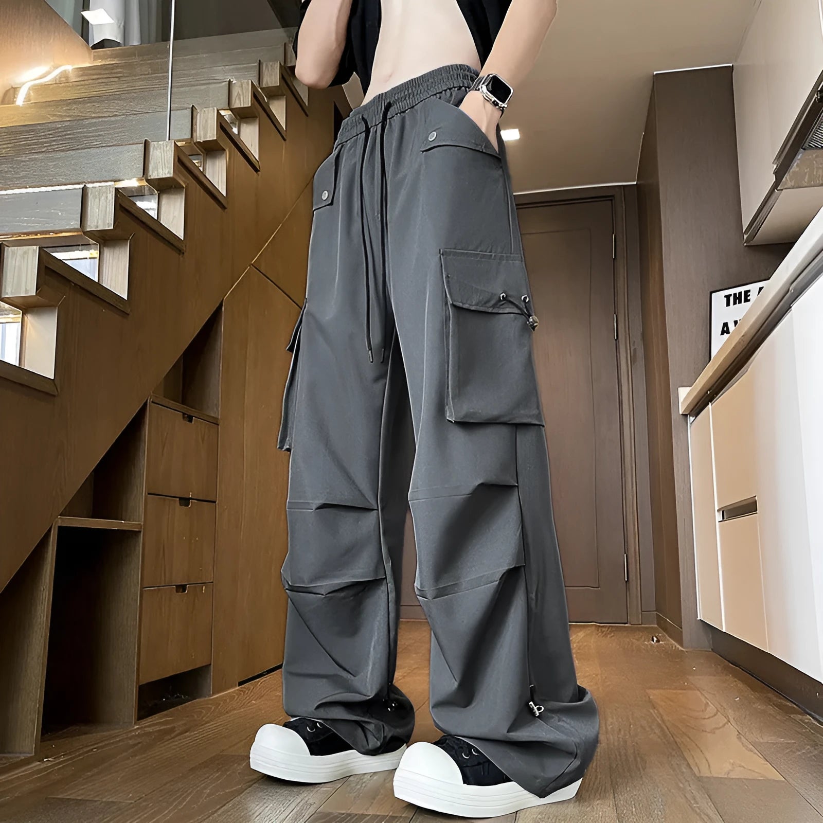 Women's plus size thin waterproof straight-leg trousers in black on a hanger, showing drawstring waist detail.