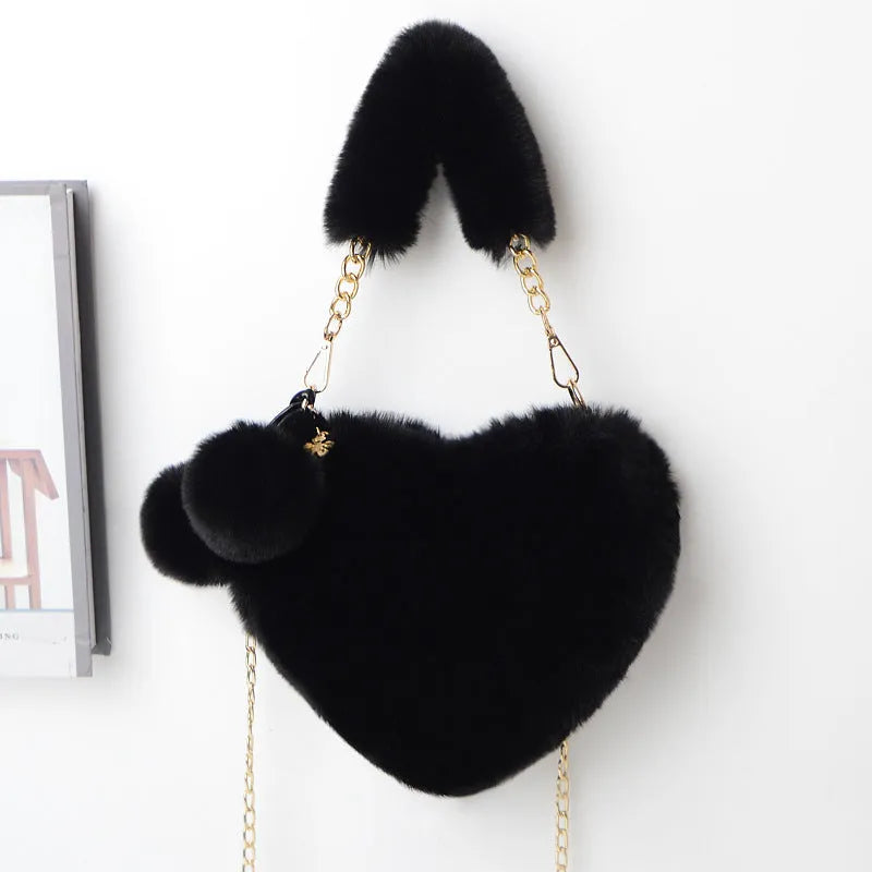 A soft, heart-shaped plush handbag for women in a medium size with a detachable shoulder strap.