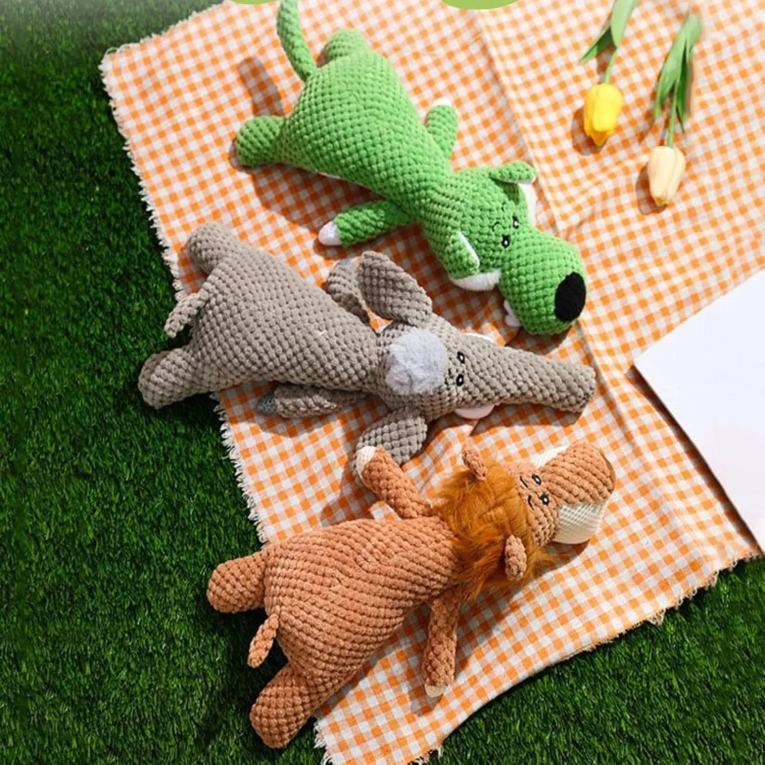 Green plush dog chew toy shaped like an animal with a corn kernel texture and a squeaker inside.