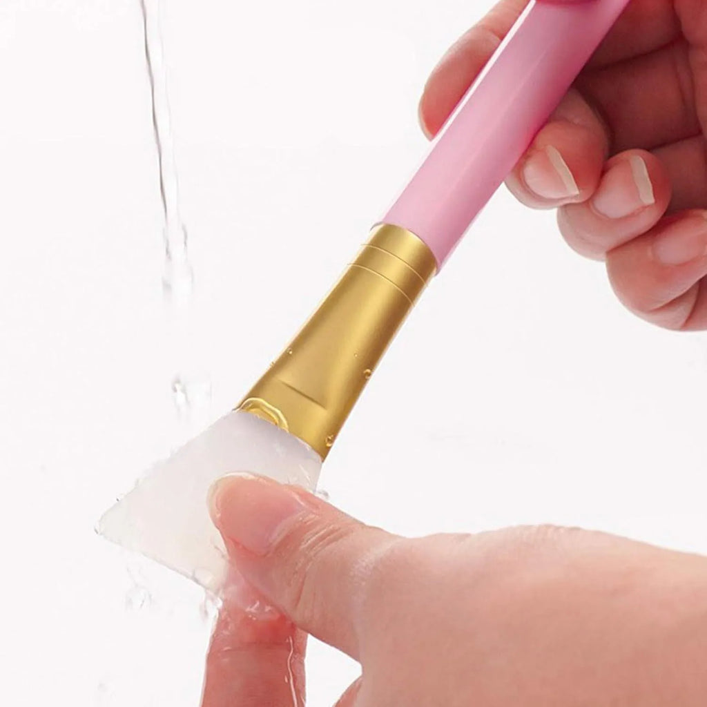 Reusable silicone face and body mask applicator spatula in assorted colours on a clean surface
