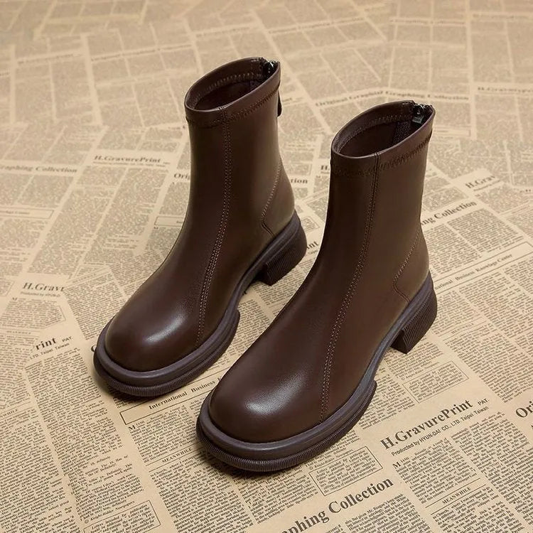 Women's black ankle boot with round toe, thick flat heel, and rear zipper on a rubber sole.