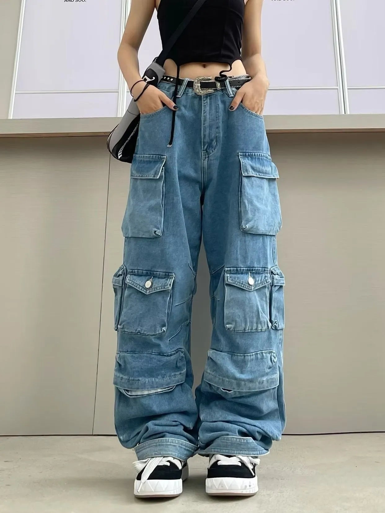 Women's blue tie-dyed high waist wide leg jeans with multiple pockets on a street style background.