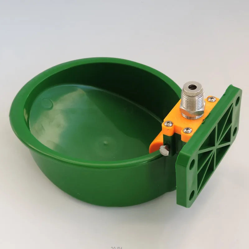 Green plastic drinking bowl for sheep and pigs on a farm.