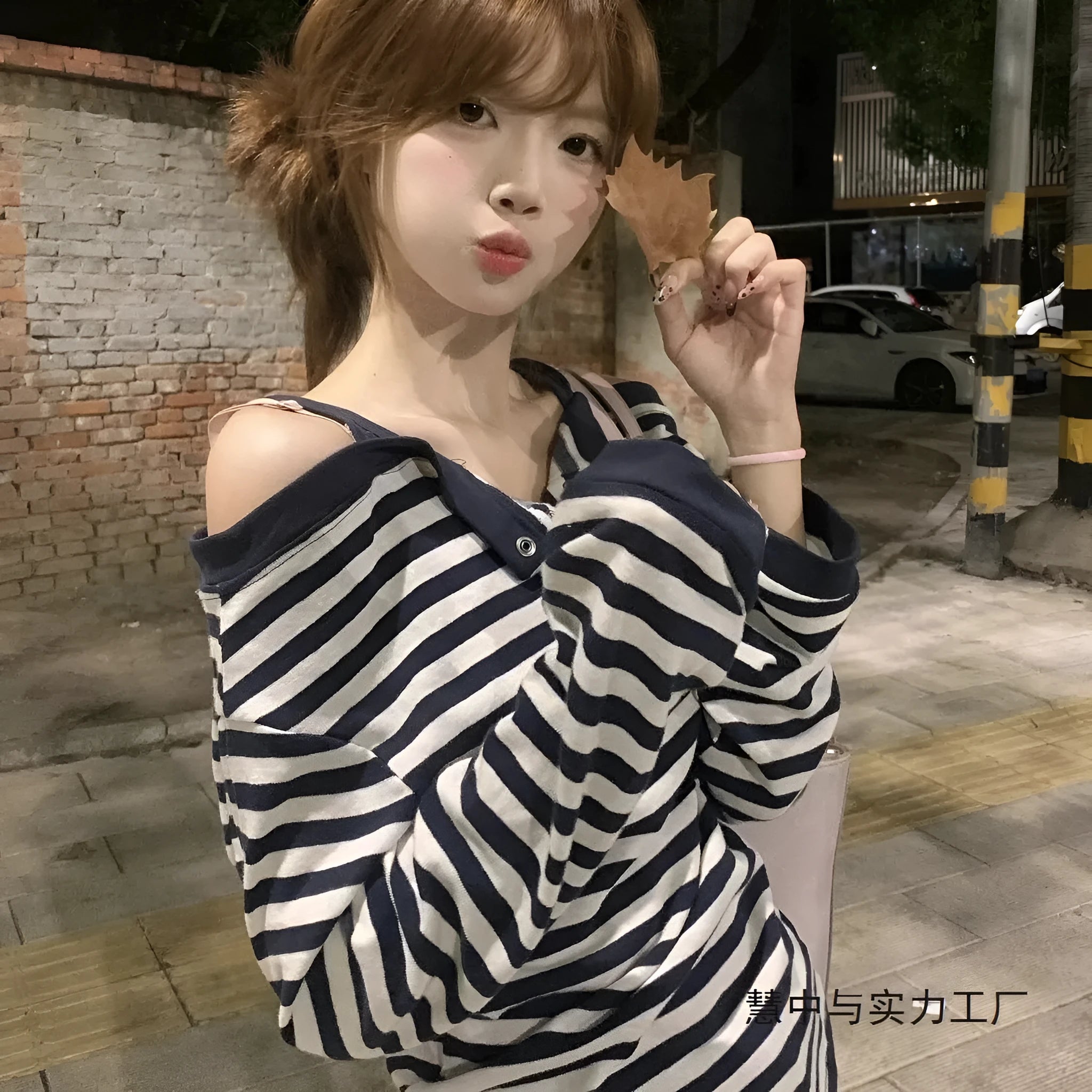 Dark blue oversized women's long-sleeve t-shirt with stripes, button detail, and embroidery on the front.