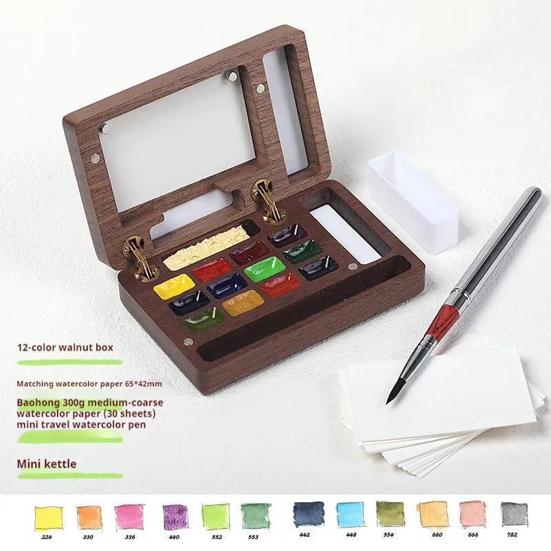 Miniature walnut wood watercolour paint box open to show pigment pans and wooden palette