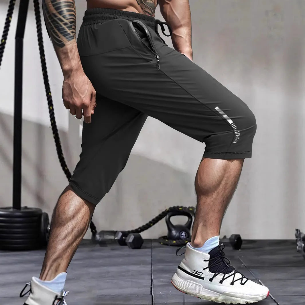 Men's grey ice silk cropped sports trousers with straight leg on a neutral background.
