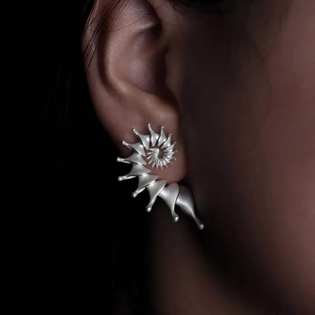 Exaggerated three-dimensional matte conch stud earrings in an alloy with an electroplated finish.