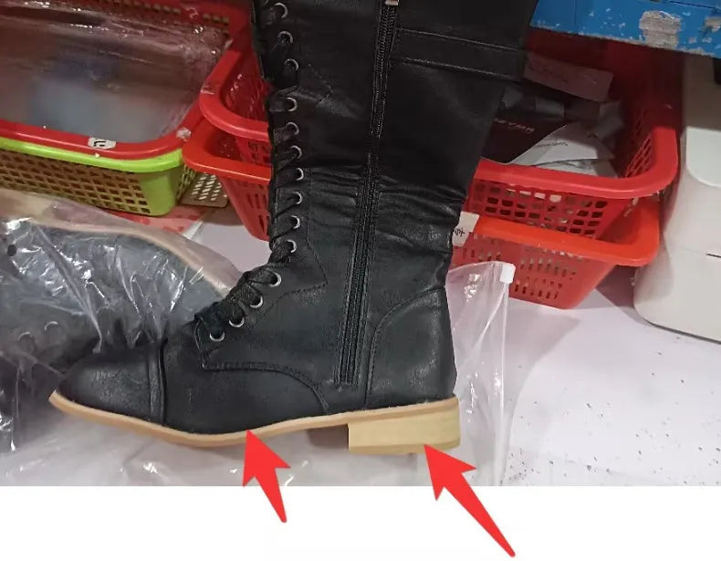 Women's black cross-strap knight boots made from artificial PU, side view.