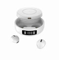 Small black semi-in-ear wireless headphones with their wireless charging case on a table.