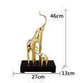 Detailed resin elephant figurine ornament in metallic gold finish on a wooden shelf.