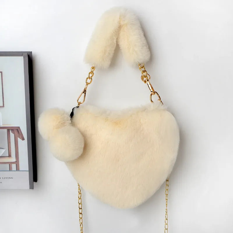A soft, heart-shaped plush handbag for women in a medium size with a detachable shoulder strap.