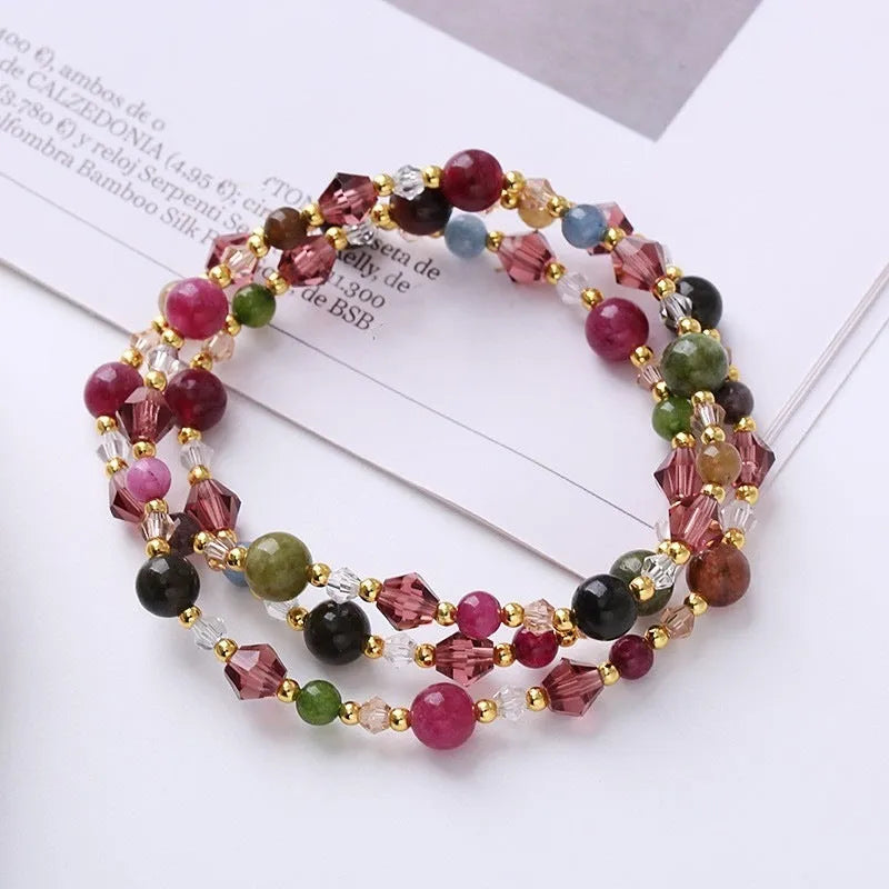 Colourful three-ring crystal bracelet with tourmaline, strawberry quartz, and amethyst beads on an adjustable cord.