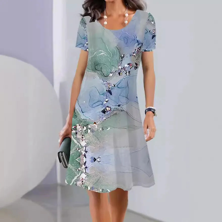 A model wearing a light blue botanical print midi dress with short sleeves and an A-line skirt.