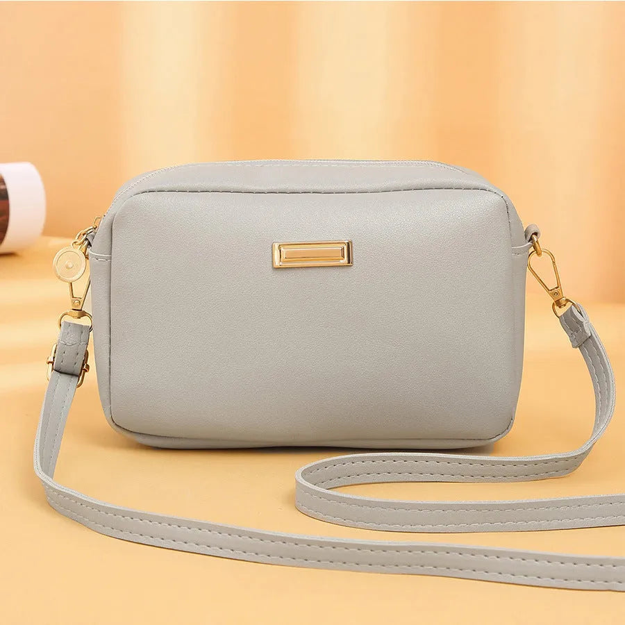 Women's solid colour PU leather shoulder bag with three-dimensional pocket and square shape.