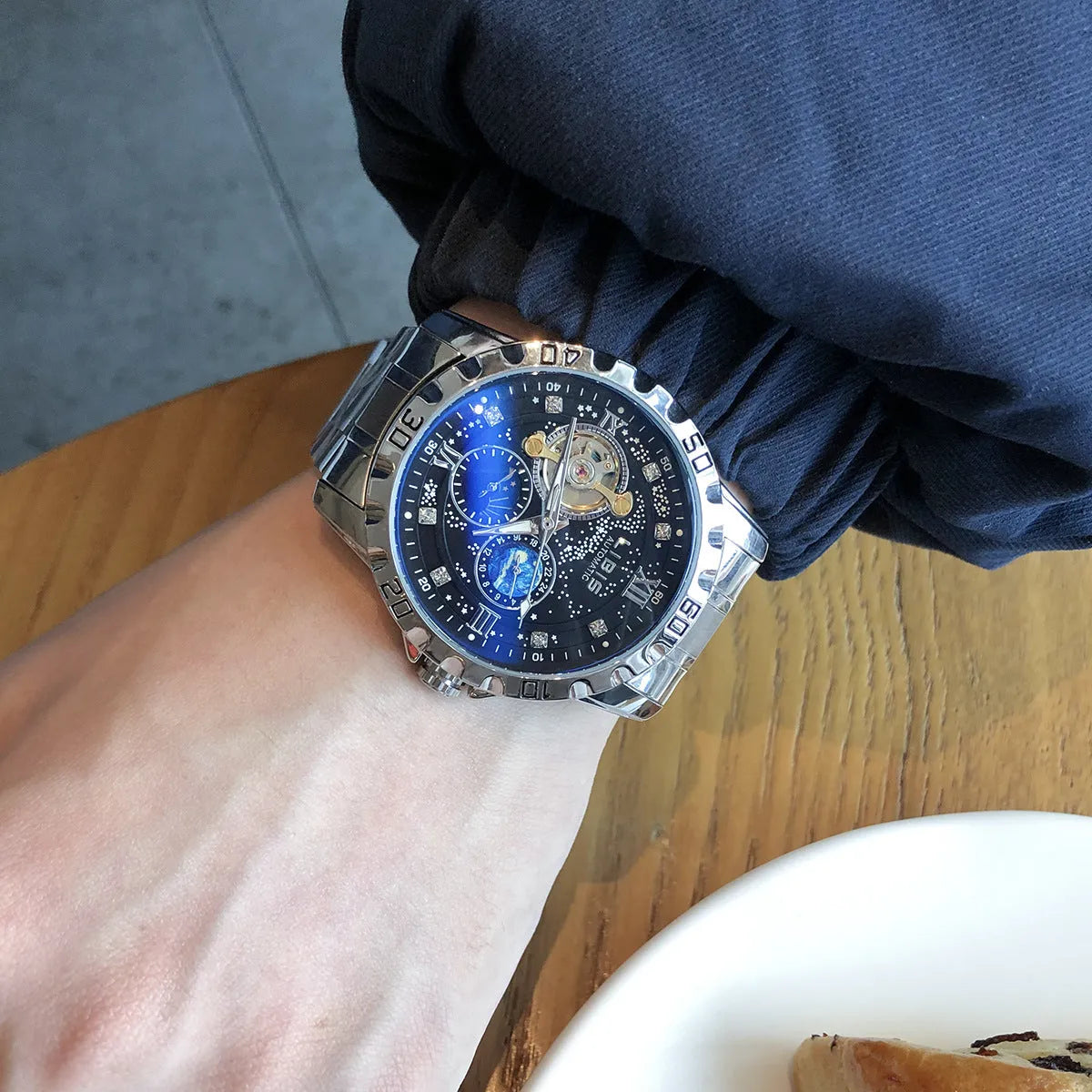 Men's silver automatic mechanical watch with starry dial, luminous hands, and black leather strap.