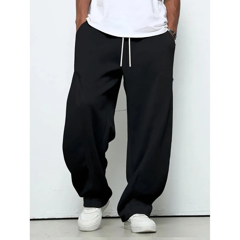 Men's straight leg casual trousers in black with a drawstring waist, laid flat.