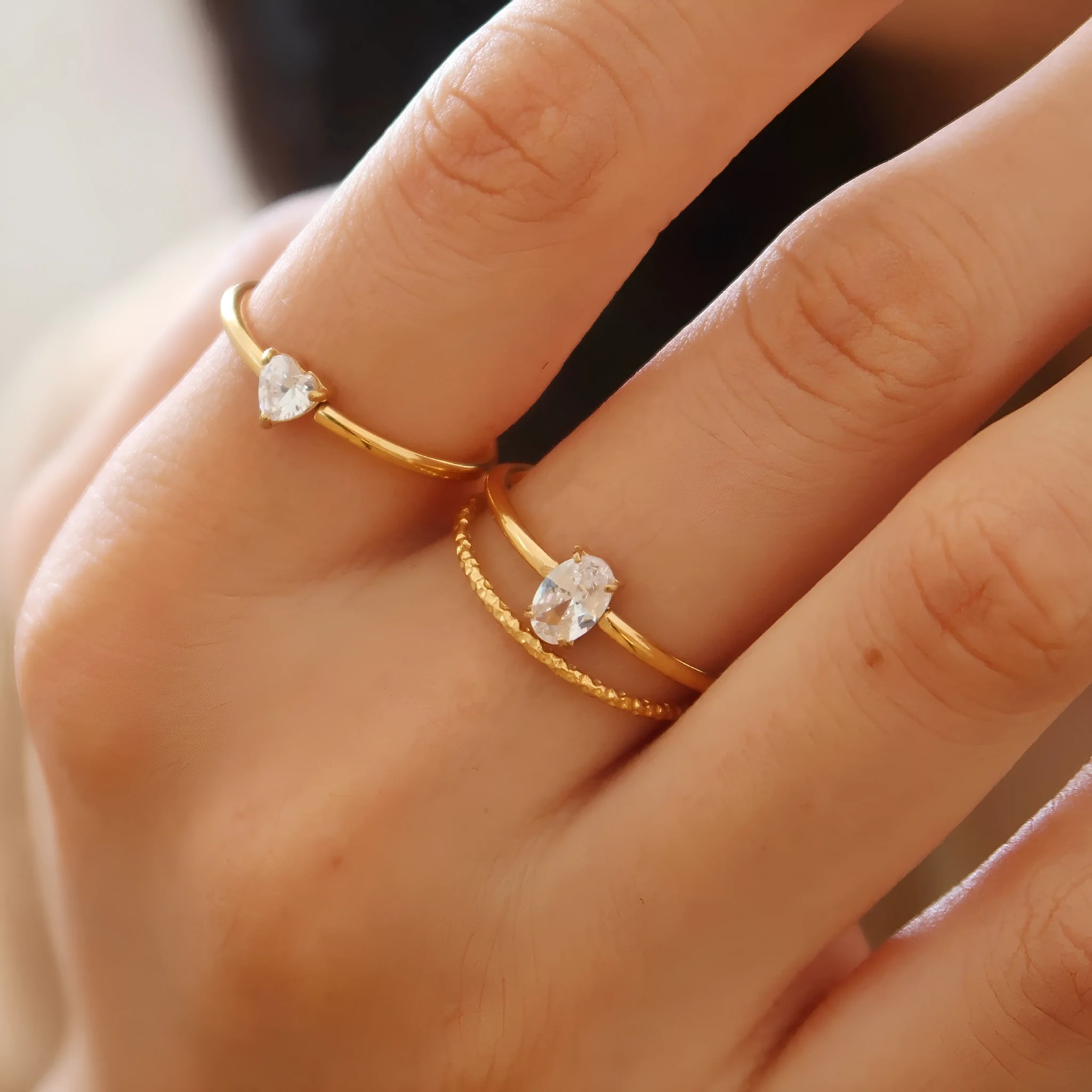 Golden stainless steel ring showing love heart and oval design options on a white background.