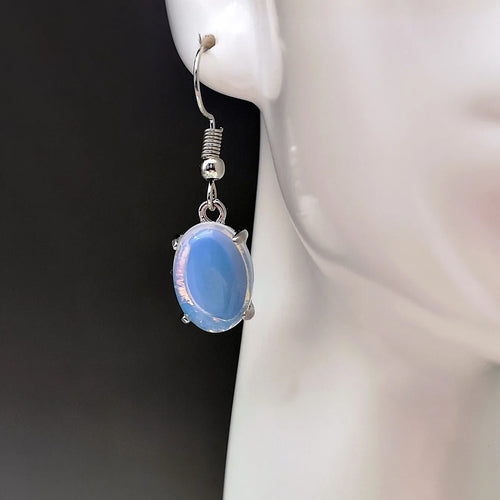 A pair of alloy drop earrings with a moonlight opal electroplated finish and a retro cross design within an ellipse shape.