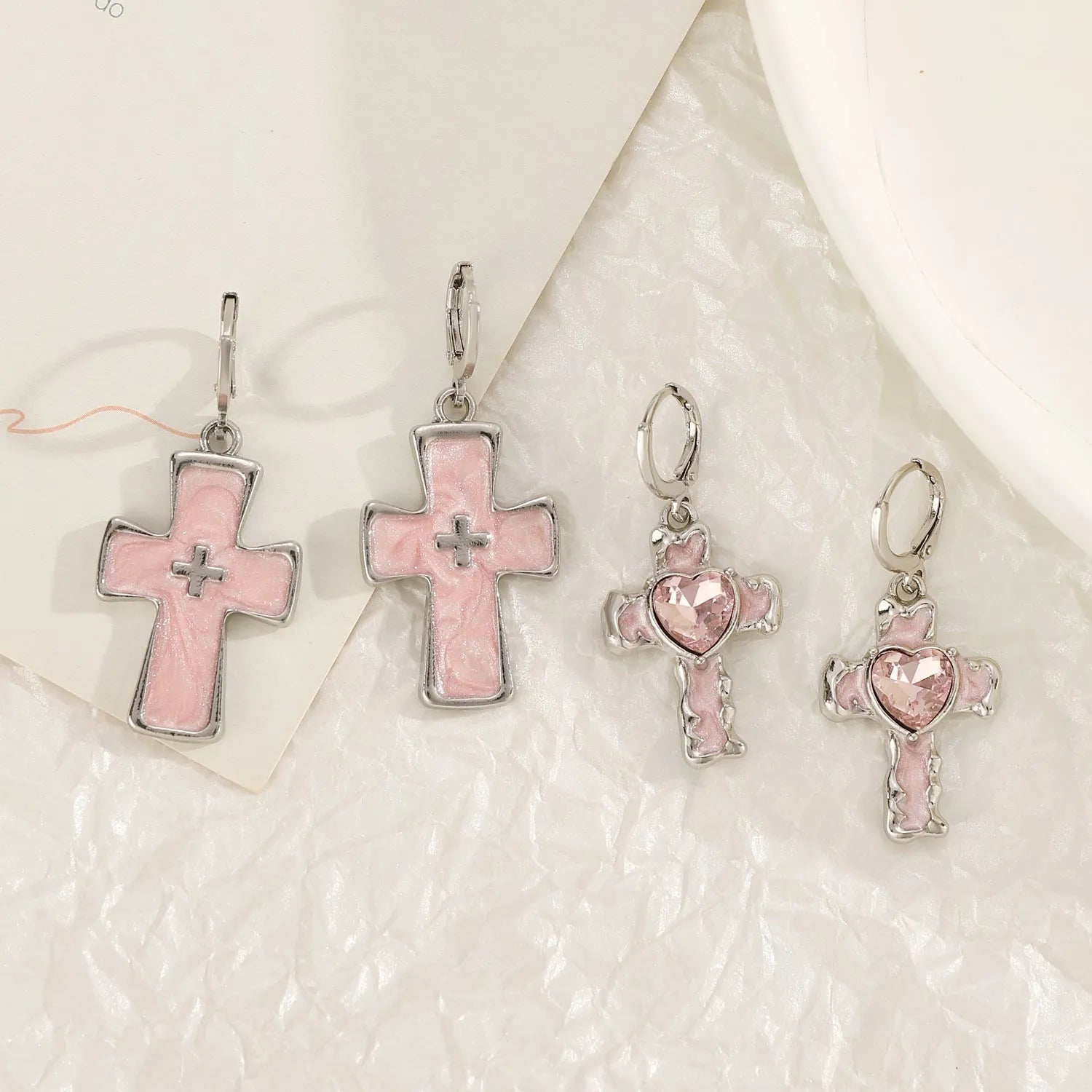 Women's alloy drop earrings featuring cross, heart, and cat charms in white, black, and antique silver finishes.