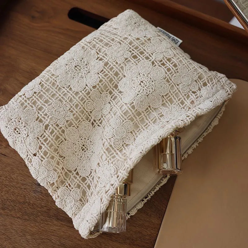 Handmade crocheted corduroy cosmetic bag with hollow flower embroidery and floral cut-out details.