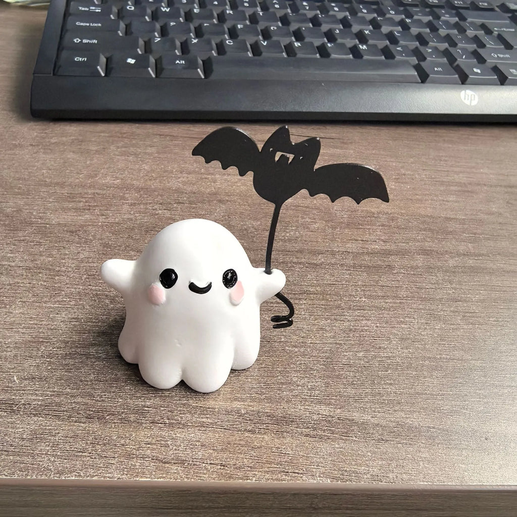 Mini ghost walking dog Halloween statue holding a bat, resin figurine on white background.