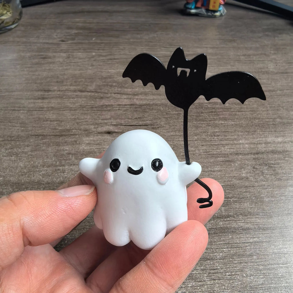Mini ghost walking dog Halloween statue holding a bat, resin figurine on white background.