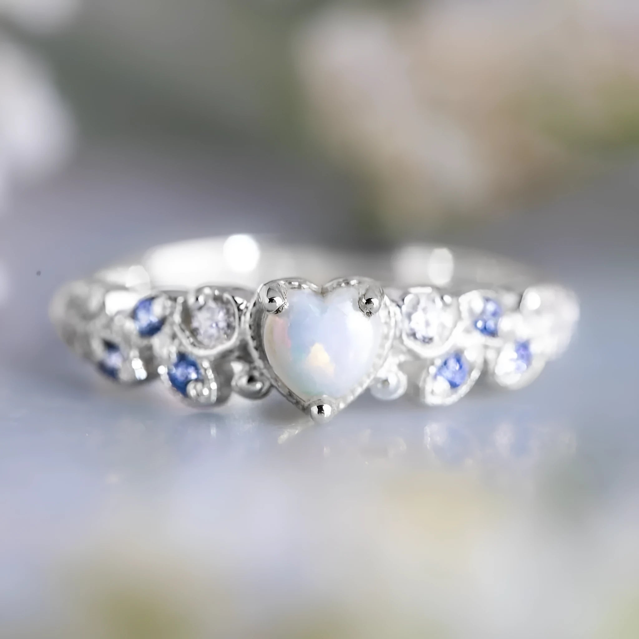 White alloy women's ring with a detailed peach heart and opal flower design.