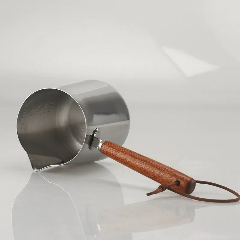 Garland stainless steel coffee milk jug with wooden handle, showing interior volume scale markings.