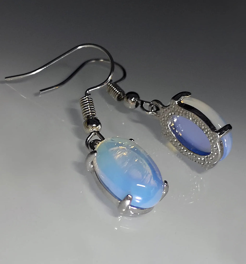 A pair of alloy drop earrings with a moonlight opal electroplated finish and a retro cross design within an ellipse shape.