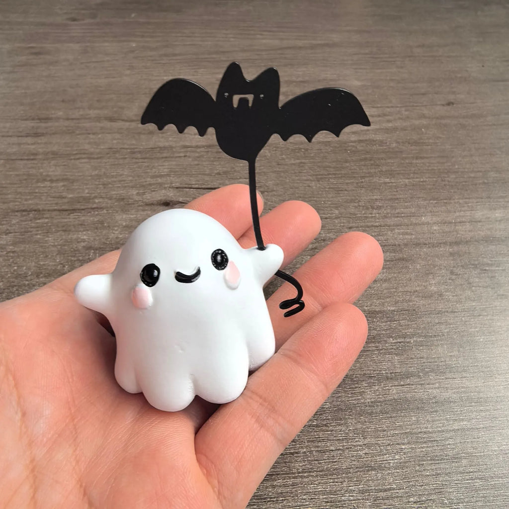 Mini ghost walking dog Halloween statue holding a bat, resin figurine on white background.