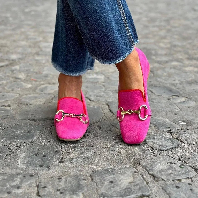 Green suede flat loafers with a round toe and shiny metal fastener on the front.