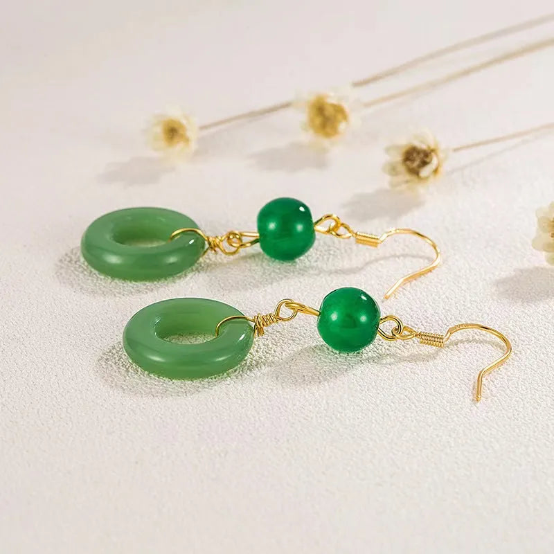 Green geometric peace buckle shape earrings with jade design on zinc alloy background