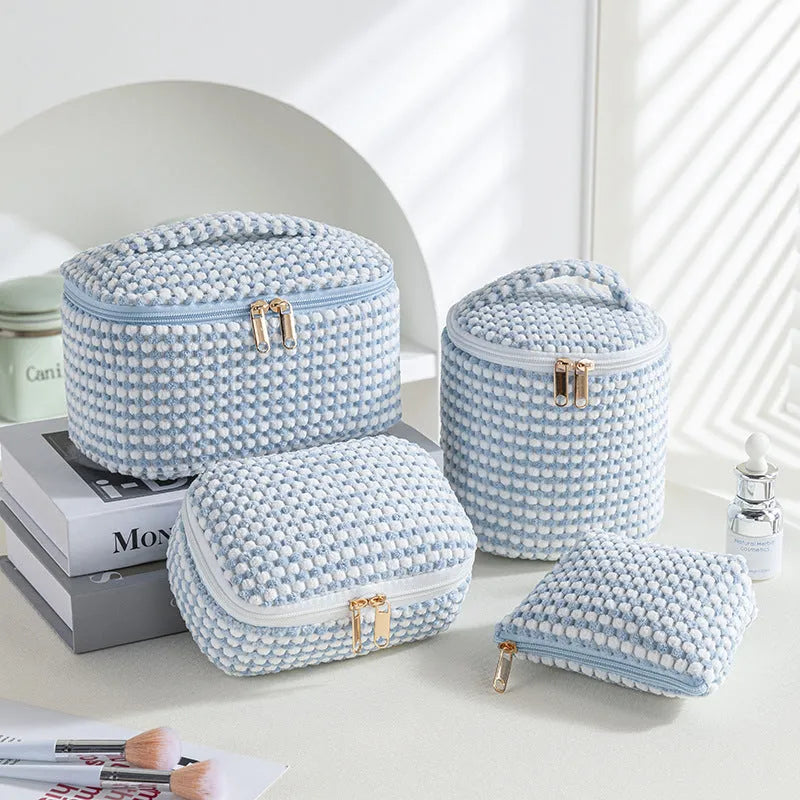 Four cube-style polyester makeup bags in coordinating colours