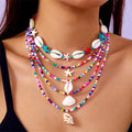 Five-piece women's necklace set with blue electroplated starfish, shell, and conch bead pendants on adjustable alloy chains.