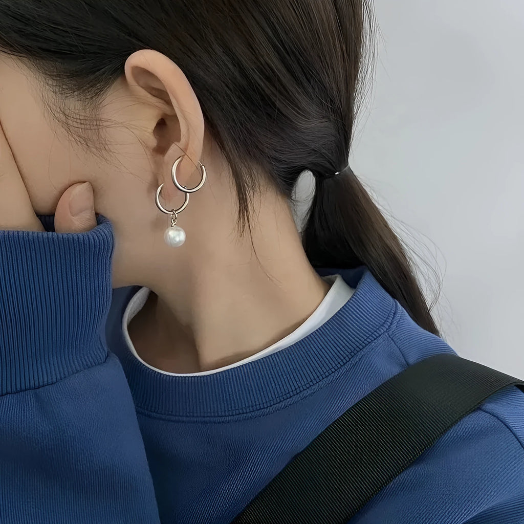 A pair of women's geometric round pearl drop earrings with a titanium steel finish and alloy construction.