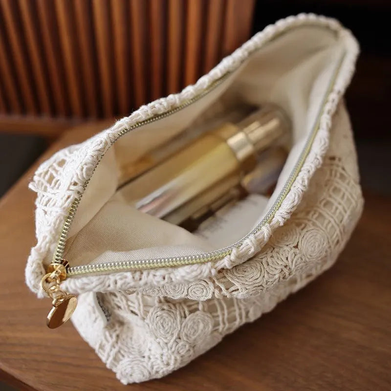 Handmade crocheted corduroy cosmetic bag with hollow flower embroidery and floral cut-out details.
