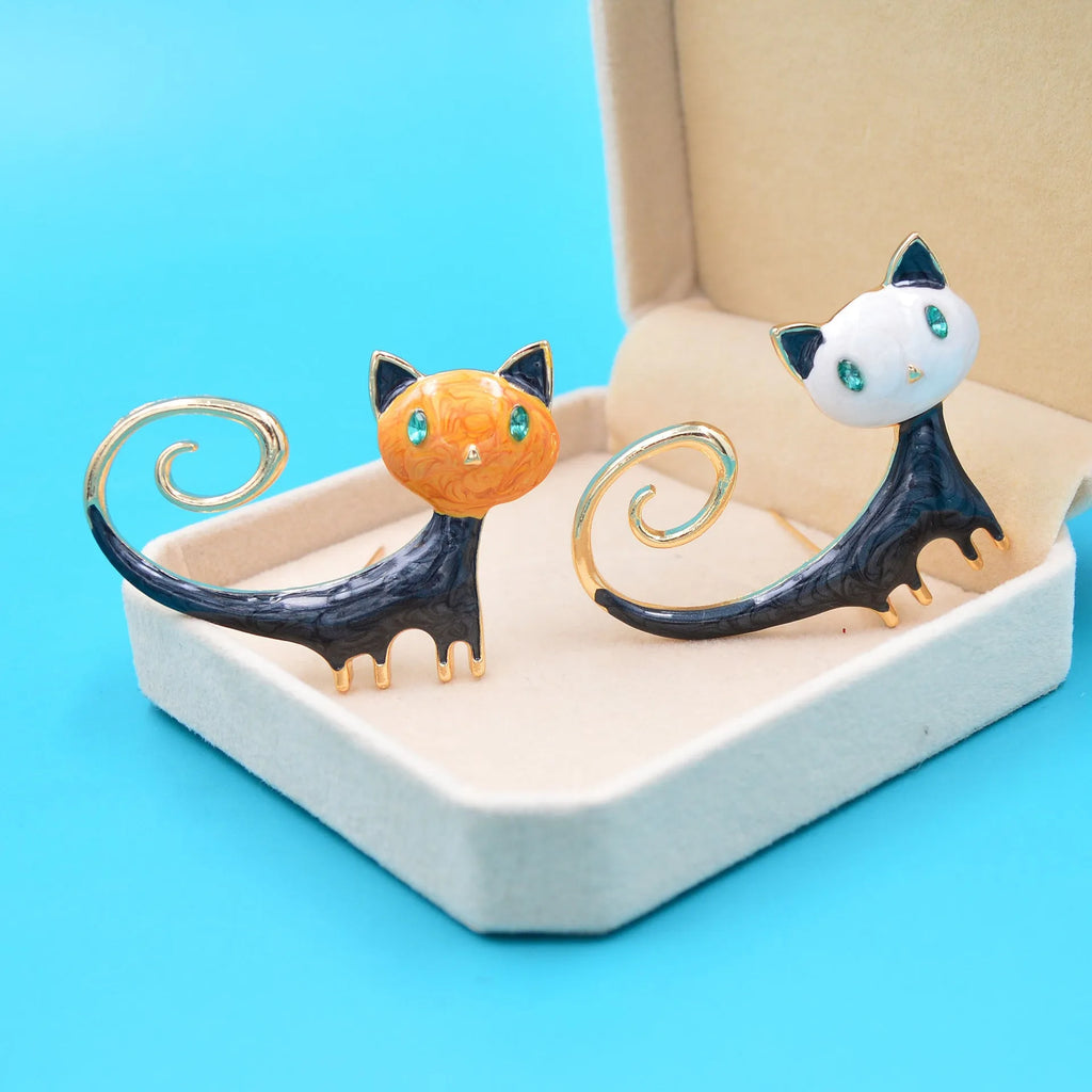 White and orange alloy cat brooch with a painted tailing up kitty design.