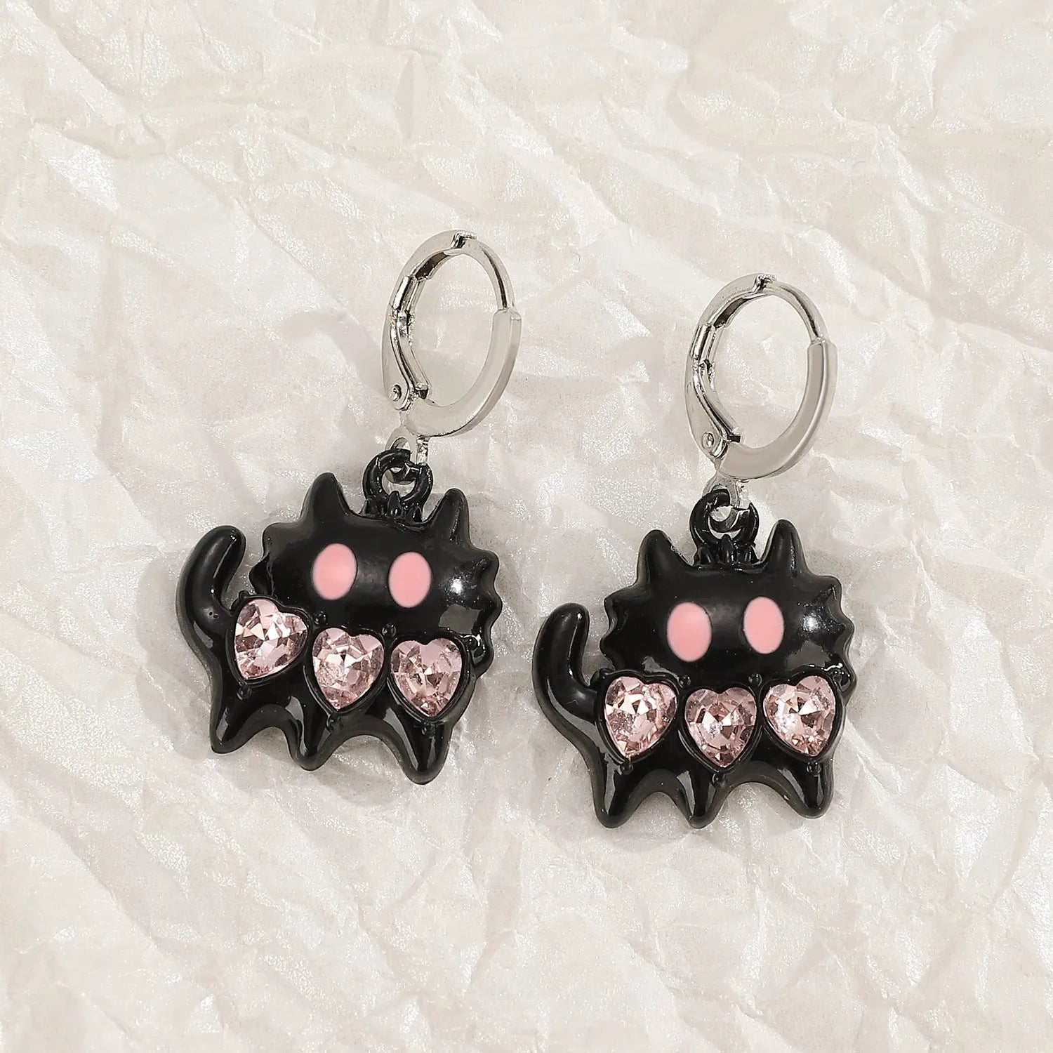 Women's alloy drop earrings featuring cross, heart, and cat charms in white, black, and antique silver finishes.