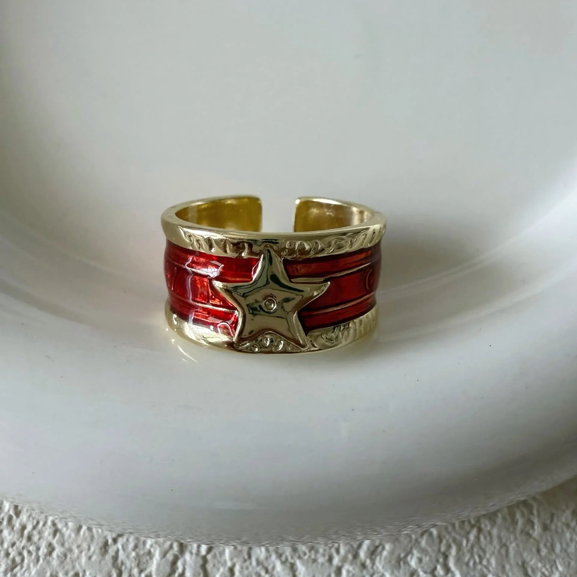 Adjustable copper drop oil ring with a distressed XINGX design in geometric shape.