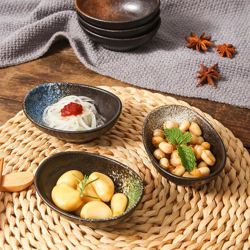 Oval Japanese ceramic sauce dipping bowl with underglaze finish on a table.