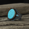 Men's antique silver alloy ring with turquoise accent on finger, showing round shape and simple design