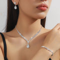 Rhinestone drop pendant necklace and matching earrings with geometric claw chain, shown in blue.
