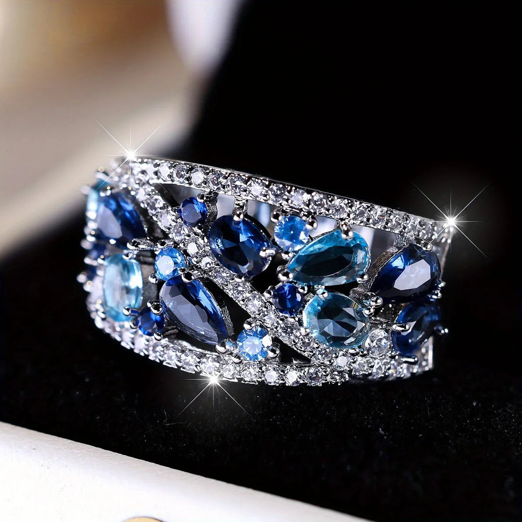 Women's round hollow fashion ring in copper with gold or platinum plating and blue or white accents